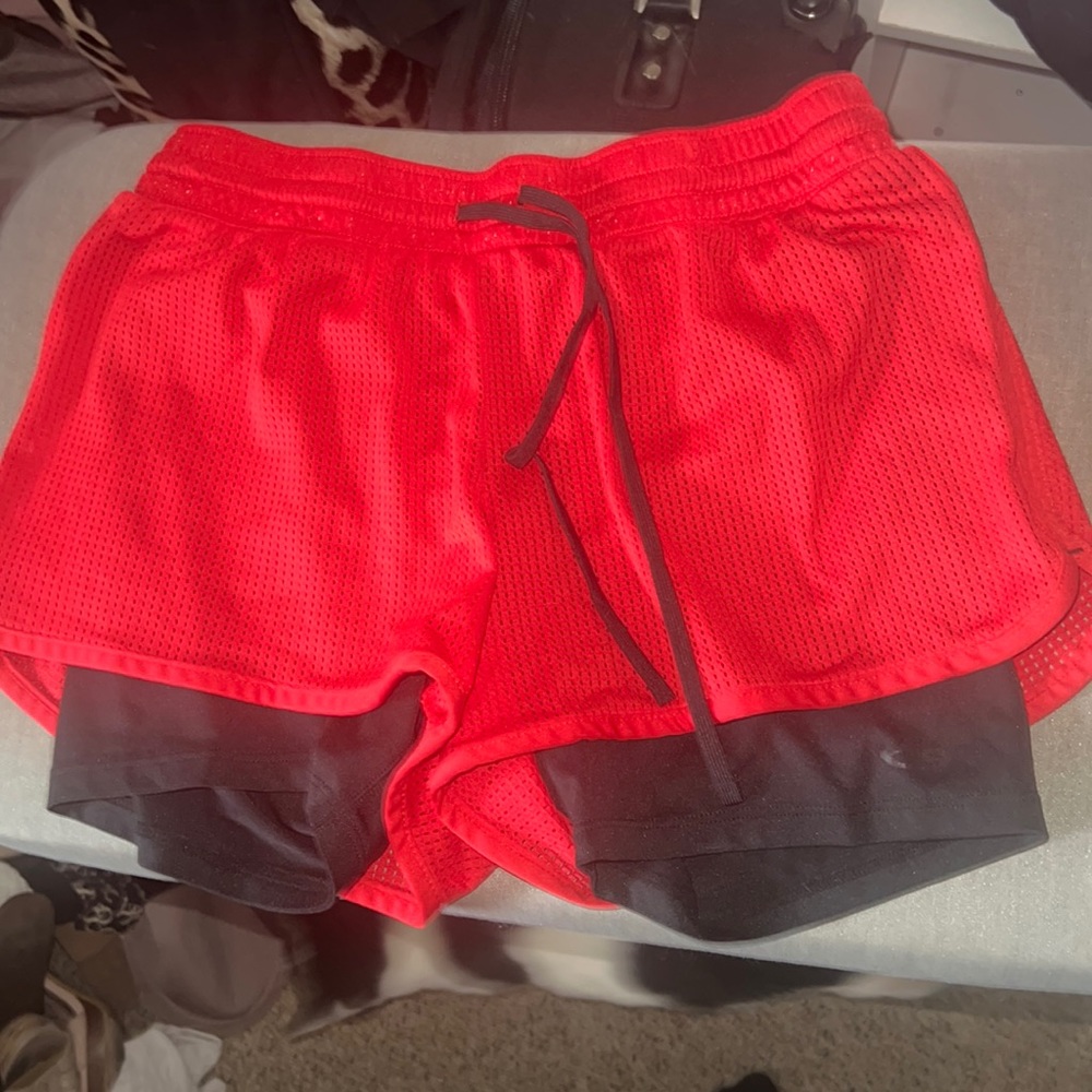Workout red shorts with attached black legging shorts under